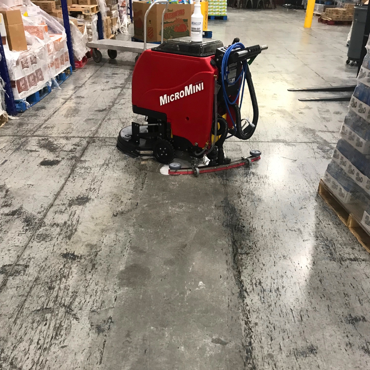 MicroMini cleaning heavy tire marks off of dirty floor in auto garage